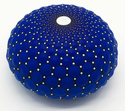 Blue mandala art 
painted on stone, showcasing intricate dot patterns and a central white dot, 
embodying mesmerizing beauty.