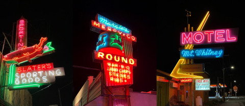 Three or four neon signs, illuminated, at night