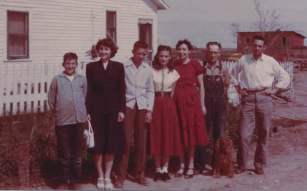 a line of folks at a Kansas 
farm: 2 boys, 2 young women, a young man, an older couple and an 
Irish Setter